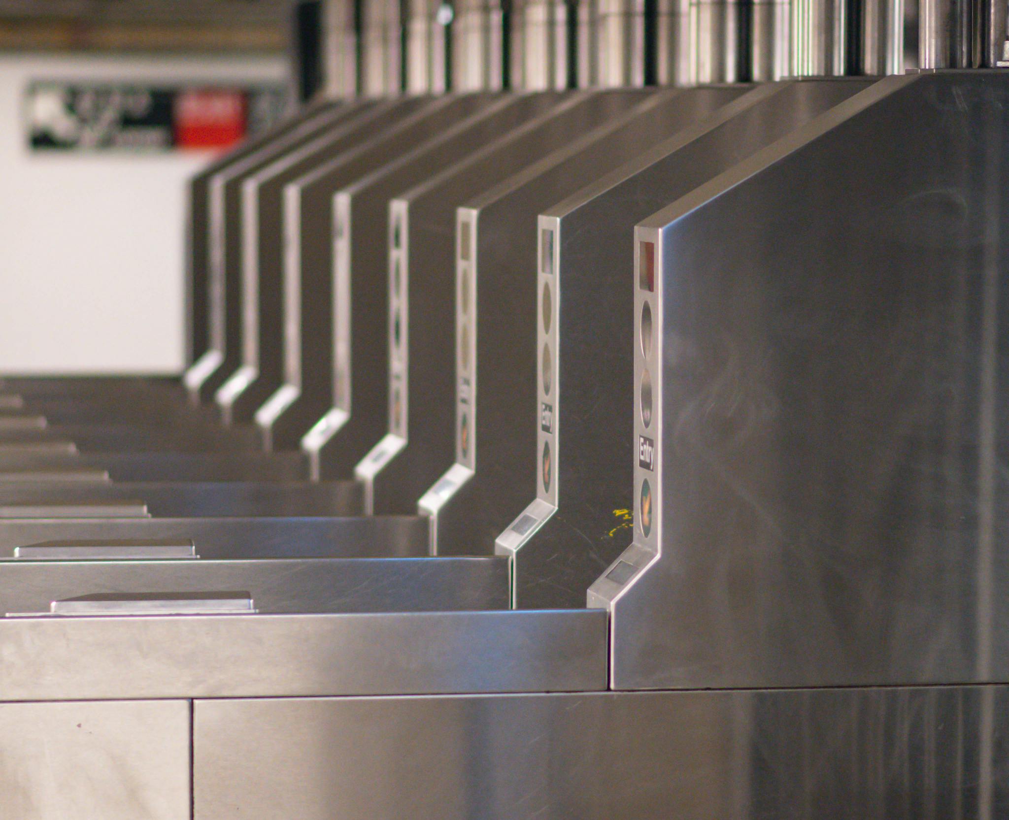 A detailed shot of multiple subway entrance turnstiles, emphasizing public transportation.